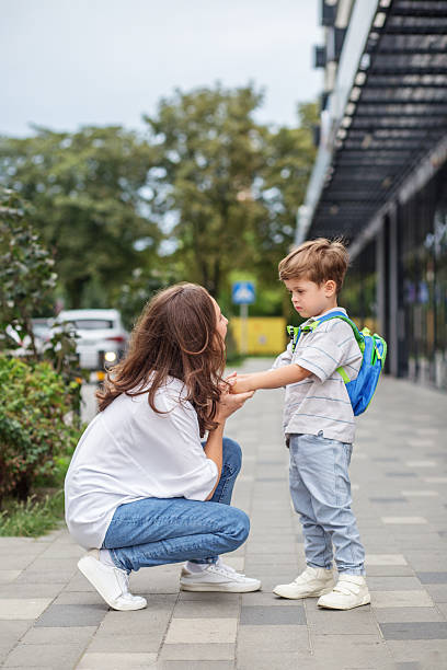 istock Mother comforting son before school outdoors 2230279820