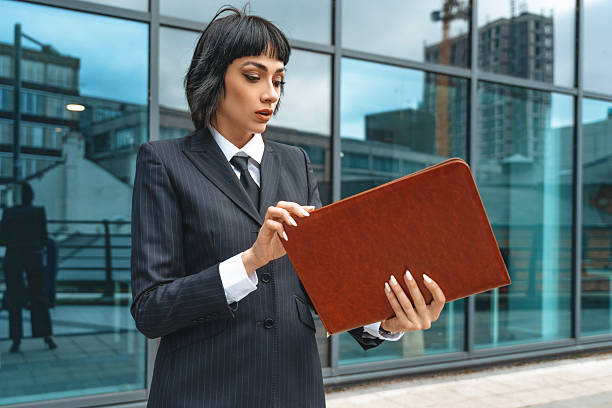 istock Business professional reviews documents outdoors in an urban setting during daytime 2230281918