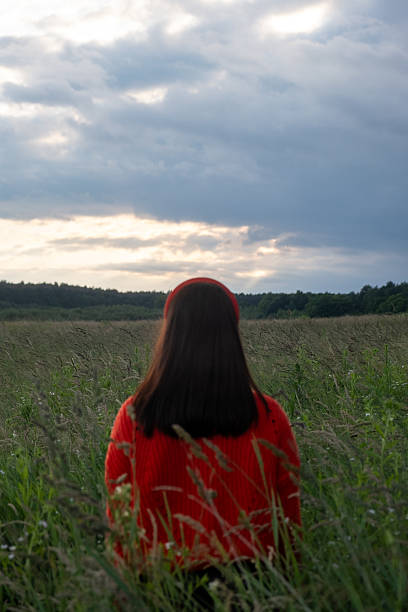 istock Woman in Red Sweater in Grassy Field 2230282568