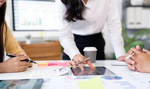istock business professionals collaborating during a meeting. Team members using digital tablets, documents, and charts to analyze data and discuss business strategy. 2230282699