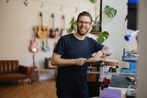 istock Luthier smiling and building a guitar in his workshop 2230283037