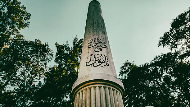 A close-up series of a memorial column dedicated to the martyrs of the Turkish War of Independence, featuring both Ottoman Turkish calligraphy and modern Turkish script reading “Vatan ve Namus” (Homeland and Honor) in Konak, Izmir, Turkey on August 14, 2025