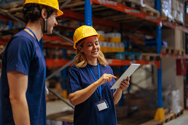 istock Female warehouse worker holding a tablet and talking to her coworker 2230292571