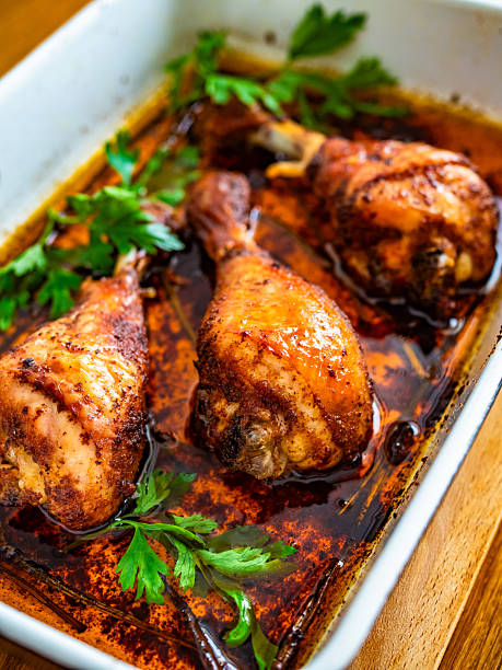 istock Oven baked chicken drumsticks in baking dish on wooden table 2230293439