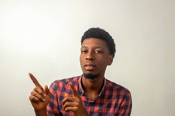 istock Choosy teen points both forefingers leftband upward while looking confidently into the camera isolated on white 2230293525