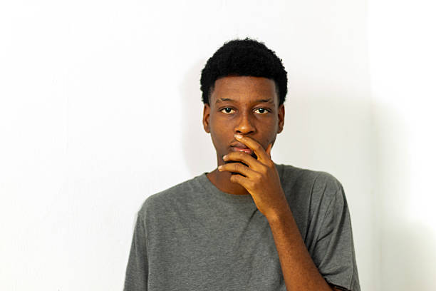 istock Teenage black boy hand to face with neutral expression  taking a decision 2230293563