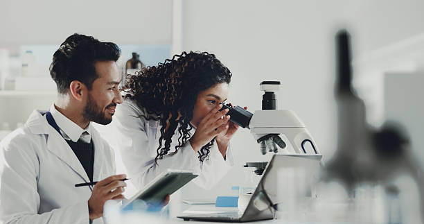 istock Scientist, team and tablet with microscope in lab for medical research, DNA testing and experiment. Science, people and microbiology equipment for sample analysis, vaccine development and innovation 2230295401