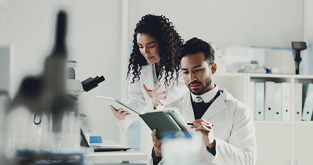istock People, scientist and tablet with research at laboratory for medical statistics, analysis or report. Man, woman or team with technology for forensic science, exam or study together at clinic trial 2230295410