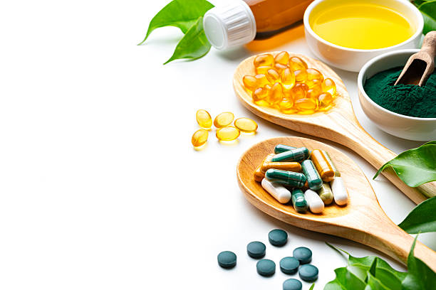 istock Nutritional supplements and natural vitamins or healthy eating and dieting on white background with copy space. Healthcare or alternative medicine. Spirulina pills and Omega-3 capsules, essential oils for health and wellness 2230299326
