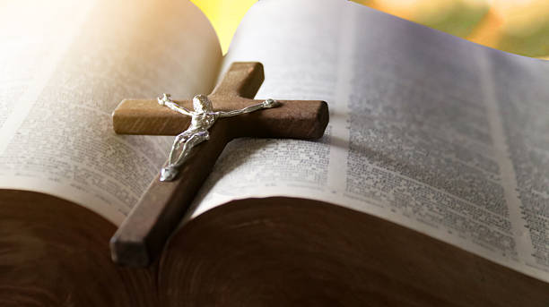 istock Wooden Jesus Cross on Old Book 2230300023