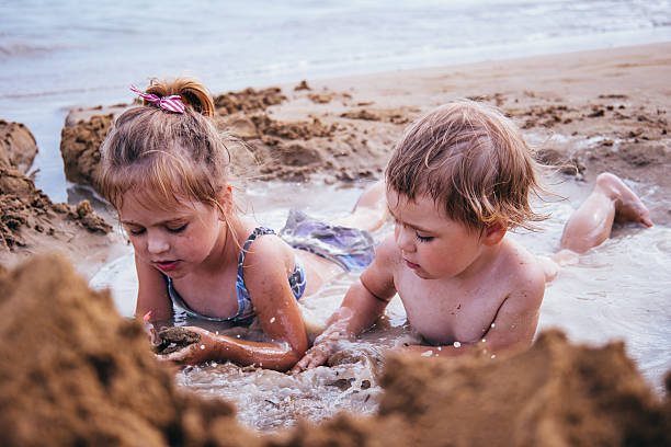 istock Two girls playing in the sand on the beach 2230301945