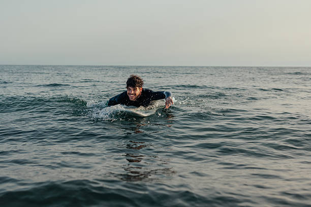 istock Surfer swimming on a surfboard 2230303390