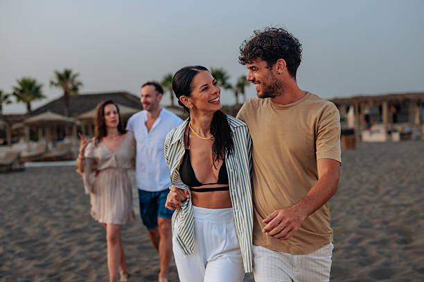 istock Couple walking and holding hands on a beach at sunset 2230303406
