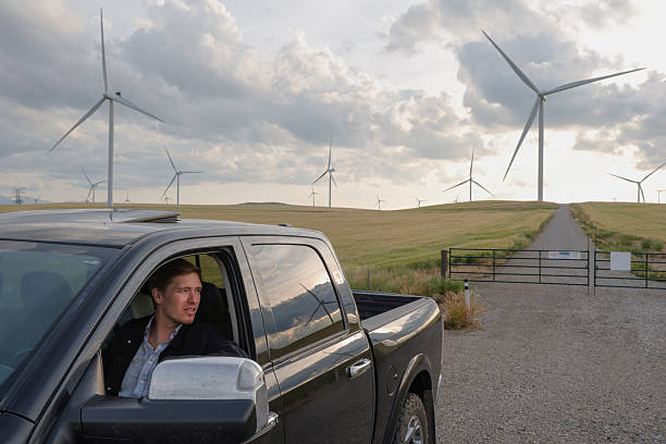 istock Young engineer, in truck, flies drone over wind turbines 2230305713