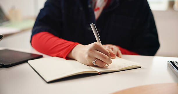 istock Remote work, hands and writing with notebook for graphic design, planning or idea inspiration. Freelancer, tablet and creative woman with schedule for project draft, reminder and diary in home 2230309217