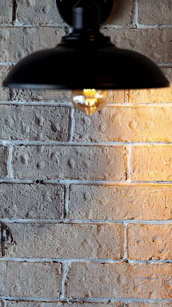 istock Vintage black metal lamp illuminating a white brick wall 2230310207