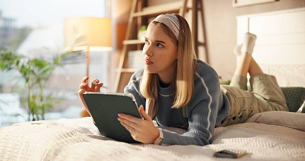 istock Online, think and woman with tablet in bedroom, research and student with assignment on web in home. Reflection, pupil and person with tech for exam, learn or knowledge for test on app or scholarship 2230317475