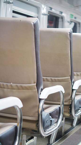 istock Close-up of beige passenger seats with white armrests inside a modern train. 2230320367