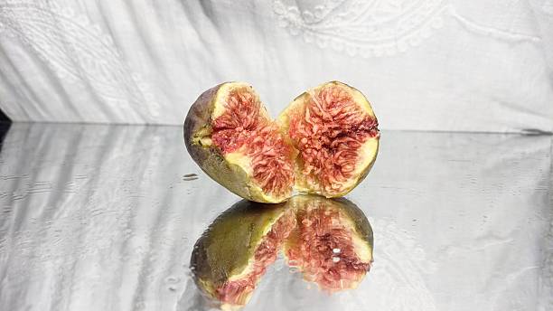 Bisected and whole fig fruit isolated on white background