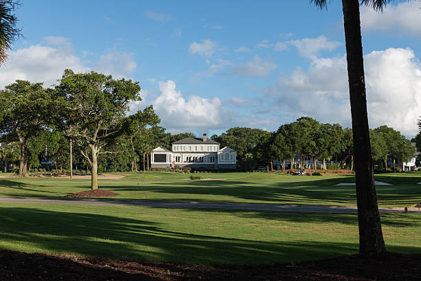 Isle of Palms, South Carolina, USA  June 30, 2025: Lush golf course landscape at Wild Dunes Resort with palm trees and a distant mansion under a bright summer sky.