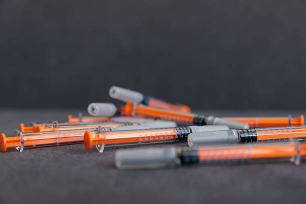istock Close-up View of Multiple Syringes with Orange Tips and Clear Bodies on a Dark Surface, Highlighting Their Precision and Medical Usage in Healthcare Context hormonal stimulation of the ovaries 2230324948