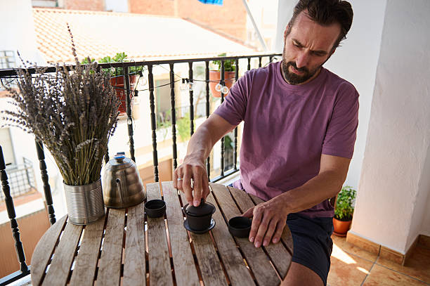 istock Man Enjoying a Relaxing Tea Ceremony on a Sunny Balcony 2230327441