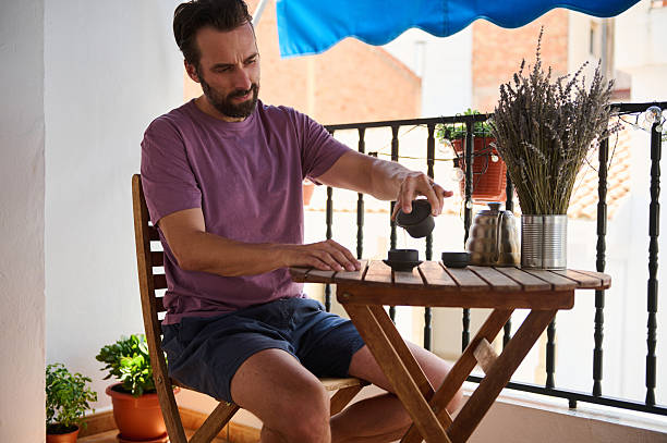 istock Man Enjoying a Relaxing Tea Ritual on a Cozy Terrace 2230327446