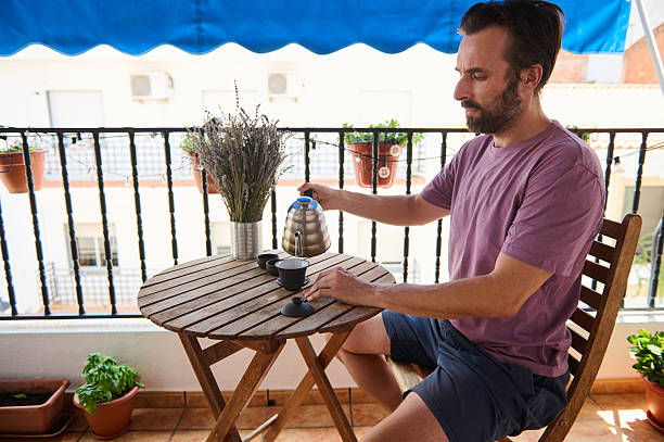 istock Man Enjoying Tea Ceremony on a Cozy Balcony With Decorated Surroundings 2230327451