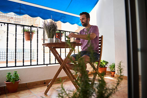 istock Man Enjoying Tea Ceremony on a Balcony Surrounded by Plants 2230327460