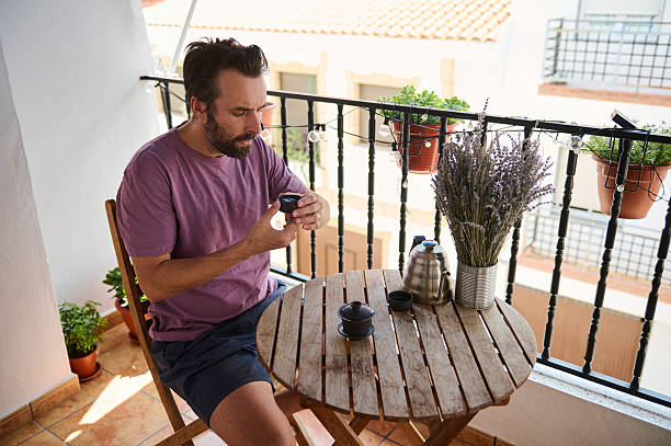 istock Man Enjoying Tea on a Balcony with Scenic Views 2230327472