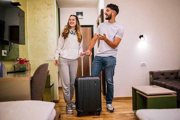 istock Young couple entering hotel room with suitcase 2230329265