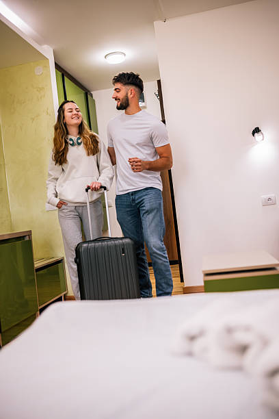 istock Young couple entering hotel room with suitcase 2230329281