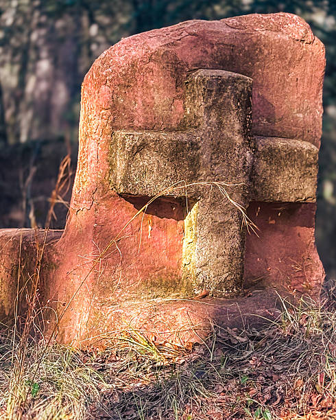 istock Weathered Stone Cross Monument in Golden Afternoon Light found in Deep Forest 2230336001