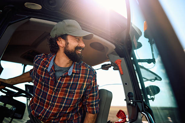 istock Happy farmer checking crops in the field from his tractor. 2230336006