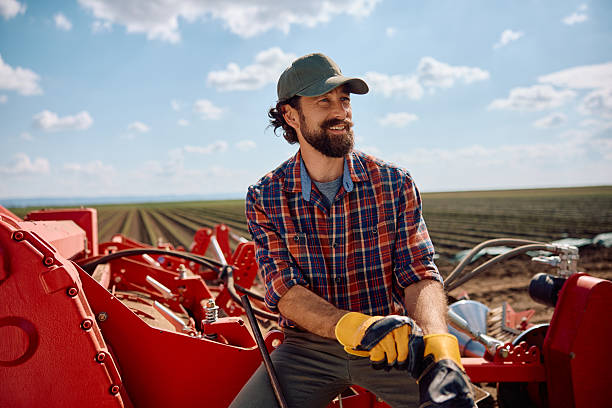 istock Happy farm worker using agricultural machinery while working in the field. 2230336027