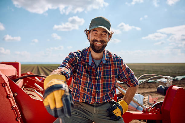 istock Happy farm worker using agricultural machine in the field and looking at camera. 2230336032