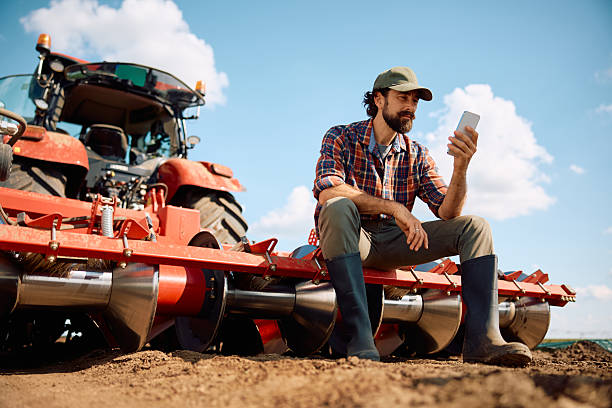istock Below view of farmer using smart phone while taking a break from working in the field. 2230336053