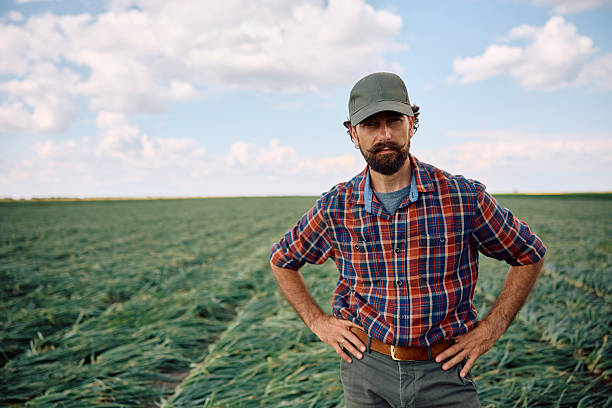 istock Mature farmer standing in agricultural fiend and looking at camera. 2230336077
