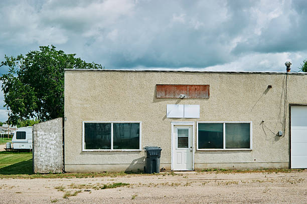 Weathered commercial building with blank signs and large front windows in a small town of Saskatchewan, Canada.