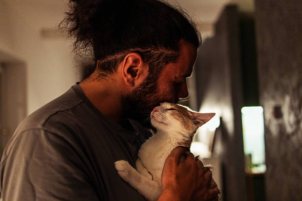 istock Man Cuddling with a Cat in a Warm Indoor Setting 2230342618