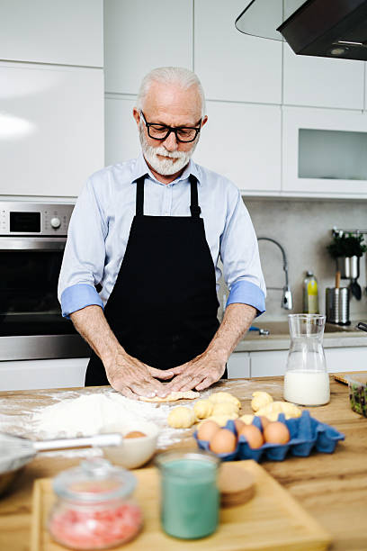 istock Senior man kneading dough in modern kitchen 2230342672