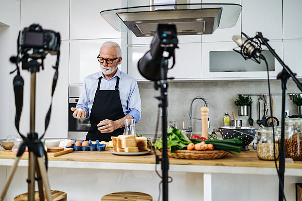 istock Senior chef recording a cooking show in a luminous kitchen 2230342718