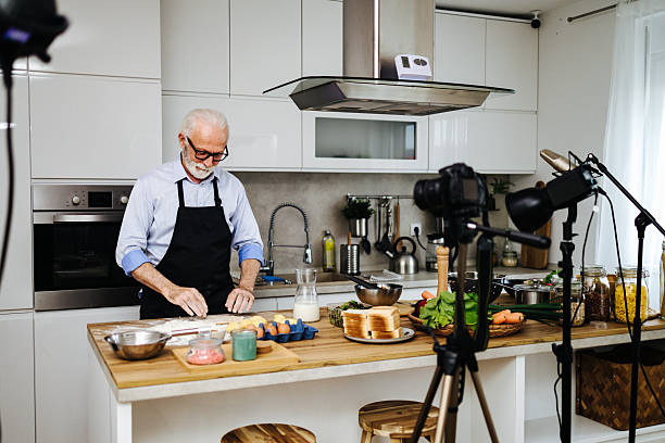 istock Senior chef recording cooking show in kitchen with professional equipment 2230342739