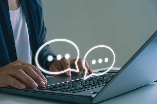 istock Close-up of hands typing on laptop keyboard with chat bubbles icon, representing online messaging, digital communication, customer service, social media interaction concepts. Online chatting support. 2230343030