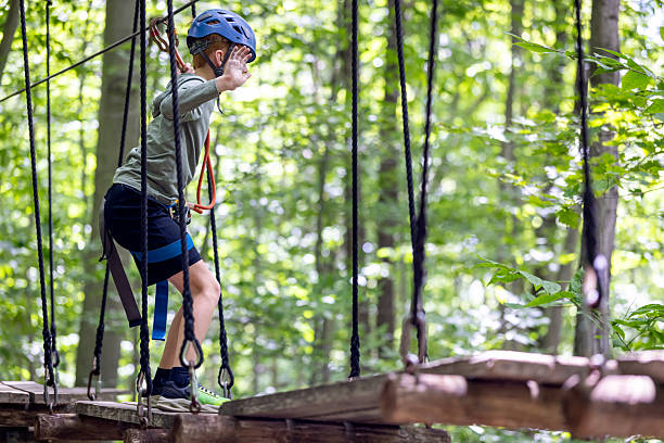 Young Boy having fun in Rope park during summer. Adventure, arbraska, arbres en arbres.