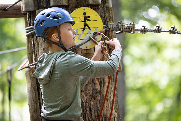 Young Boy having fun in Rope park during summer. Adventure, arbraska, arbres en arbres.
