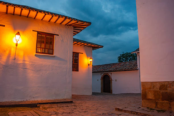 Beautiful street scene in Villa de Leyva, Boyaca, Colombia, featuring white colonial architecture illuminated by warm lanterns.