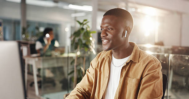 istock Graphic designer, music and man in office on computer for web development, website and ui design. Creative agency, digital tech and person with earphones for online research, planning and software 2230354276