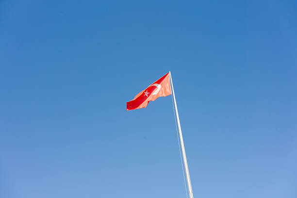istock Red flag with a star on it is flying in the sky 2230354433