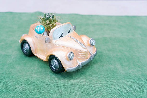 Toy car with a blue flower in the front. The car is sitting on a green cloth